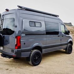 a grey van parked on top of a sandy beach