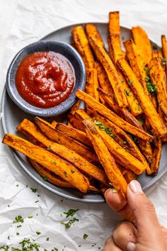 a plate full of baked sweet potato fries with ketchup on the side,