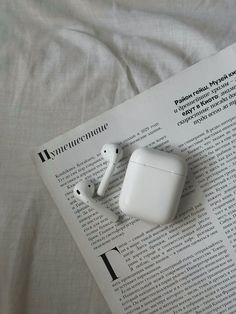 an apple airpods sitting on top of a newspaper