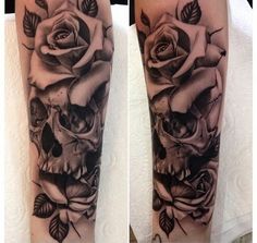 a black and white photo of a skull with roses on it's forearms