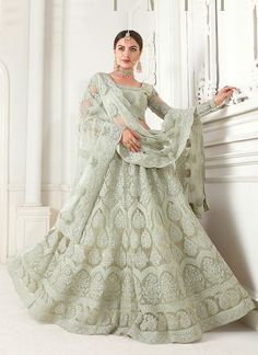 Light Green Pearl Embroidered Wedding Lehenga Choli is best pick as an indian wear for festivals or wedding event. This elegant set has a very pretty thread embroidery detailed with zari and pearl work on canned net lehenga with satin lining paired with equally embellished matching net and satin choli and ethnic motifs embroidered net dupatta. Team this beautiful attire with classic pair of heels and golden jewellery to look like a diva. *This set comprises of a designer choli top, lehenga botto Pastel Lehenga, Green Lehenga Choli, Lehenga Choli Designs, Indian Wedding Lehenga, Nikkah Dress, Lehenga Online