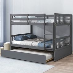 a bunk bed with a trundle underneath it on the floor next to a window