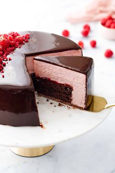 a chocolate and raspberry cake with one slice cut out