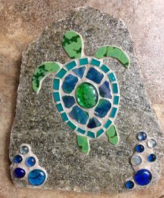 a turtle made out of sea glass on a granite slab with blue and green accents