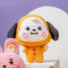 two crocheted stuffed animals sitting next to each other on top of a table