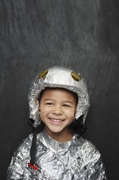 a little boy wearing a silver helmet and smiling