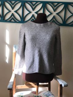 "Banana Republic 3/4 sleeve figure flattering sweater knit from Capucci Italian yarn in gray and cream wide neck the linear draw in at waist, then flairs out to where it sits just above hips. Size Ladies Medium  Fabric wool yarn      Color  Cream & Gray            Made in Hong Kong         Bust  34\" at rest             Shoulder  14\" top across         ] Waist  30\" at rest               Length 22\"         Neckline 9\" across  (opening 18\")   Arm length top 21\" inseam 16\"     Condition soft Cozy Stretch Tops For Work, Textured Knit Long Sleeve Cropped Sweater, Textured Knit Cropped Long Sleeve Sweater, Textured Stretch Cropped Sweater For Layering, Fitted Soft Knit Long Sleeve Top, Textured Knit Long Sleeve Cropped Sweater For Layering, Long Sleeve Textured Knit Cropped Sweater For Layering, Gray Long Sleeve Knit Top For Spring, Stretch Cropped Sweater With Soft Knit And Long Sleeves