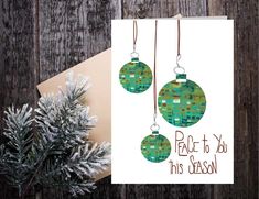 a christmas card with three ornaments hanging from it's strings and the words peace to you this season