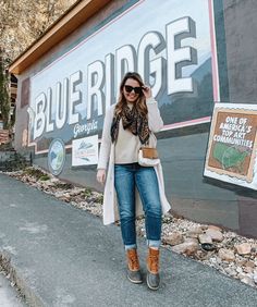 a woman standing in front of a blue ridge sign