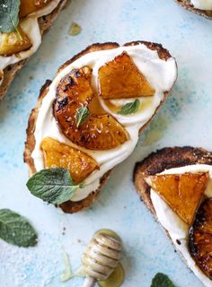 toasted bread topped with sliced oranges and whipped cream on a blue tablecloth