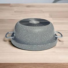 a gray pot sitting on top of a wooden table