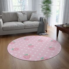 a living room with a white couch and pink polka dot round rug on the floor