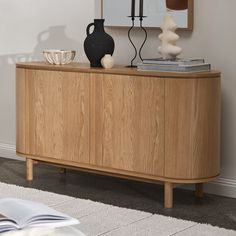 a wooden sideboard with two vases on top and a mirror hanging above it