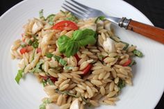 a close up of a plate of food with pasta and spinach leaves on it