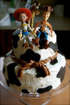 a cake decorated with toy figurines on top of it