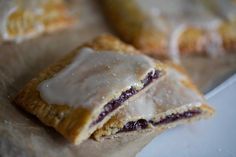 two pastries sitting on top of a piece of wax paper next to each other