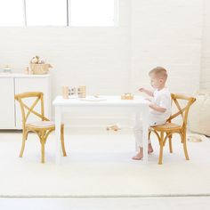 a little boy sitting at a white table