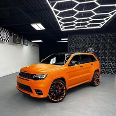 an orange jeep is parked in a garage