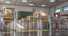 rows of empty school desks in an empty classroom