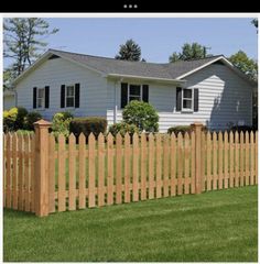 a wooden fence in front of a white house