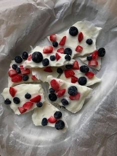 fruit pizza with white frosting and blueberries on a piece of waxed paper