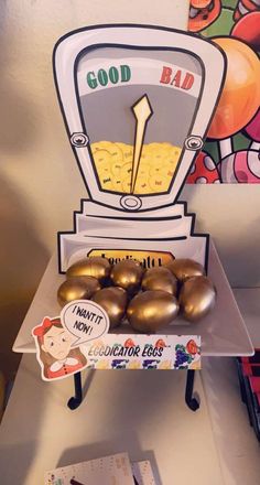 some gold eggs sitting in front of a good bad sign on top of a table