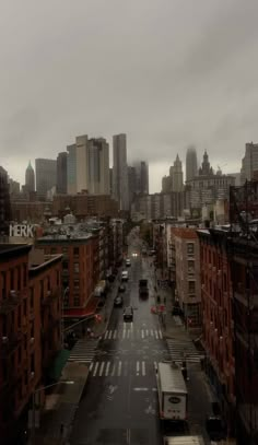 an empty city street in the middle of a large city with tall buildings on both sides