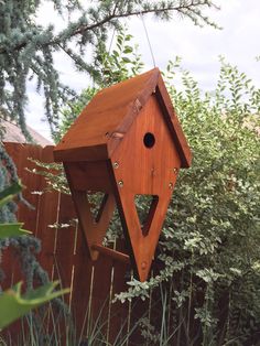 a wooden bird house hanging from a tree