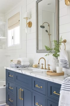 a white and blue bathroom with gold accents