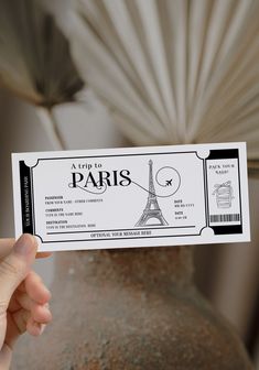 a person holding up a ticket to the eiffel tower in paris, france