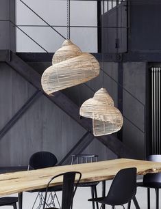 three lamps hanging from the ceiling above a table with chairs and tables in front of it