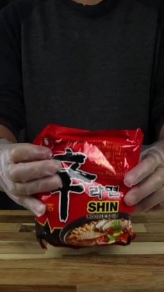 a person holding a bag of food on top of a wooden table