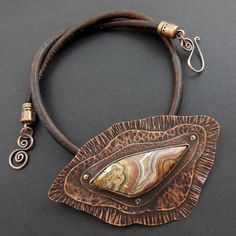 Freeform cut crazy lace agate has earthy coloring of browns, peach and white. The multi layered copper setting has different textures that are riveted together. Brown leather cording necklace has hook closure. Cabachon Jewelry, Flame Painting, Rivet Jewelry, Cold Connections, Edgy Necklace, Apocalyptic Clothing, Copper Work, Metal Jewelry Making, Metal Pendant Necklace