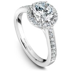 a white gold halo style engagement ring with round diamonds on the shoulders and sidestones