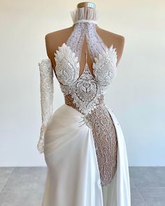 the back of a white wedding dress with sheer lace and beadings on it