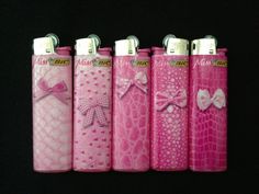 four pink lighters with bows on them