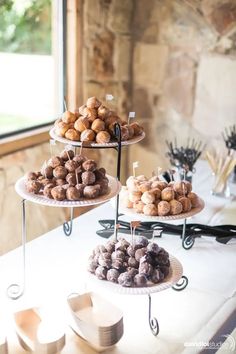 three tiered trays filled with donuts on top of a table next to a window