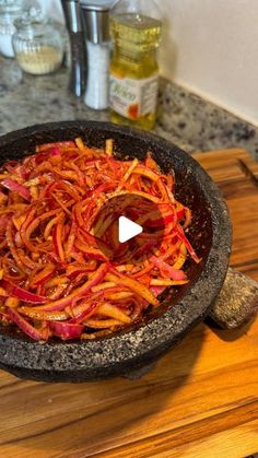 a frying pan filled with food on top of a wooden cutting board