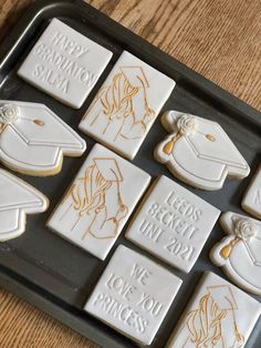 cookies decorated with graduation caps and diplomas on a cookie sheet