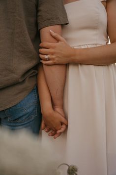 a man and woman holding each other's hands while standing next to each other