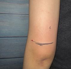 a woman's arm with a small tattoo on the left side of her arm