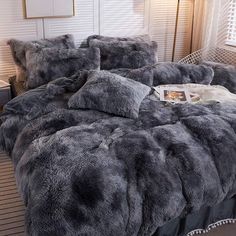 a bed covered in grey fur with pillows