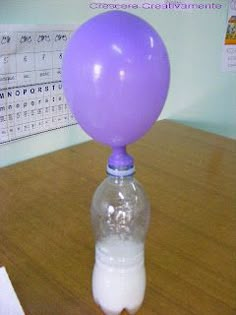 a purple balloon sitting on top of a plastic bottle