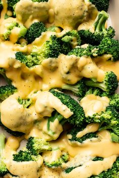 a blue plate topped with broccoli covered in cheese sauce and gravy