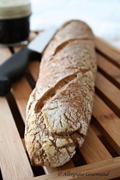 a loaf of bread sitting on top of a wooden cutting board next to a knife