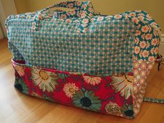 a large floral bag sitting on top of a hard wood floor