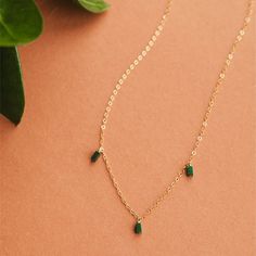 On a neutral background is a gold chain necklace with three rectangle emerald stones dangling from three different points on the chain. Trio Necklace, Adornment Jewelry, Green Stones, The Shade, Gold Chain Necklace, Green Stone, Dark Green, Jewelry Collection, Stone