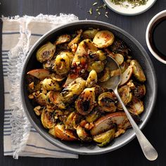 a bowl filled with brussel sprouts next to two cups of coffee