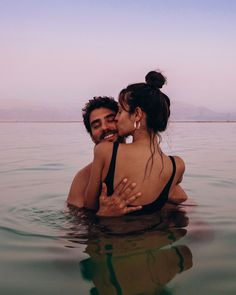 two people in the water hugging each other