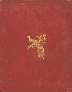 an old red book with a gold bird on it